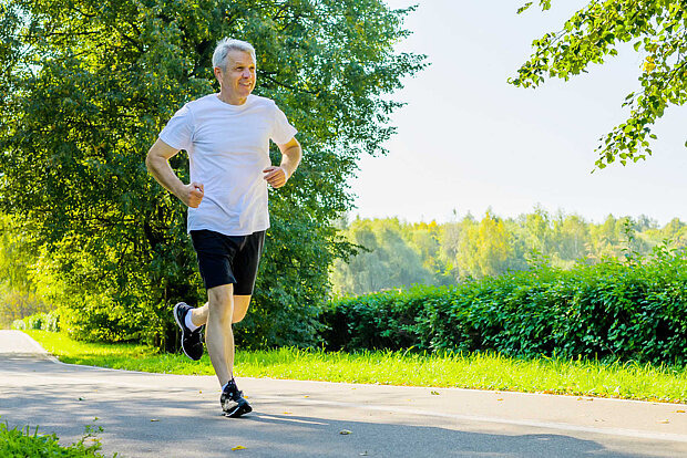 Fitness und Sport Aktiver älterer Mann rennt durch den Park.