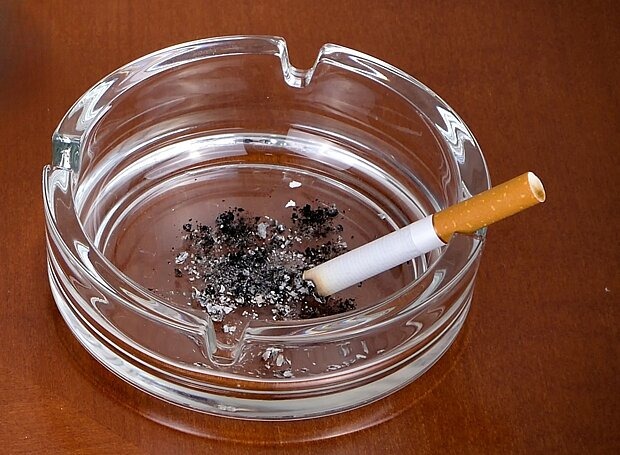 Tipps zum Rauchstopp Aschenbecher mit Zigarette