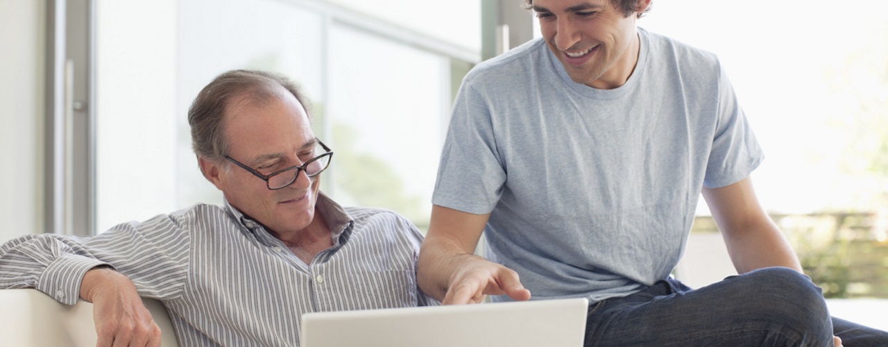 Vater und Sohn schauen auf Laptop